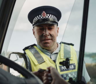 About the job image of a police officer approaching through car window