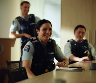 Can I be a cop image of three police officers with a table in the foreground