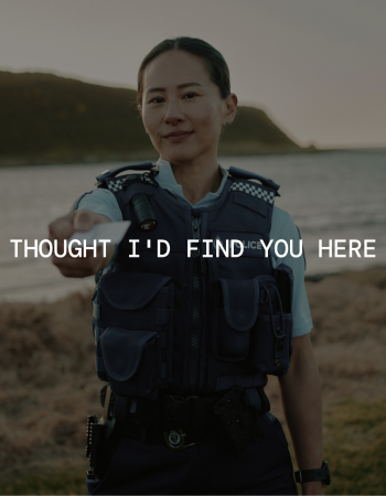 Image of female police officer on beach presenting a card with words in front of image Thought I'd Find You Here
