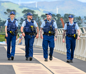 Four Police Officers walking together on a bridge